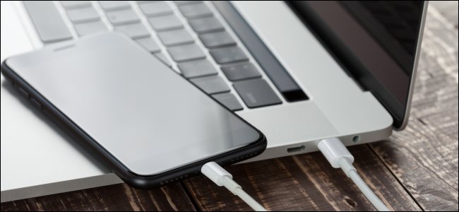 An iPhone plugged into a MacBook with a Lightning-to-USB-C cable.