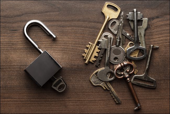 Multiple keys next to an open padlock.