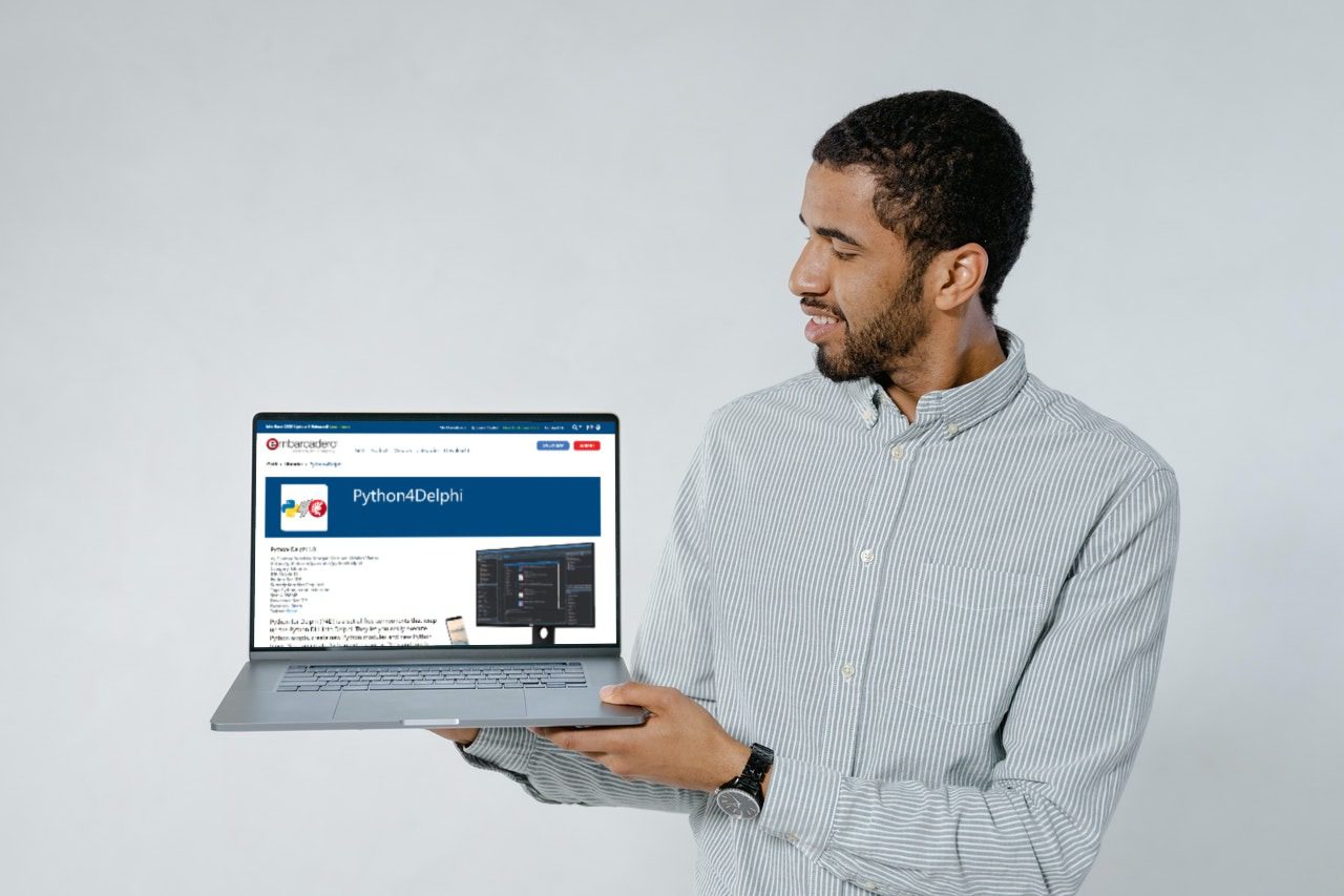 5 Examples Of Best Python Graphs - a person looking at a laptop held in their hands. The screen shows the Python4Delphi project page.