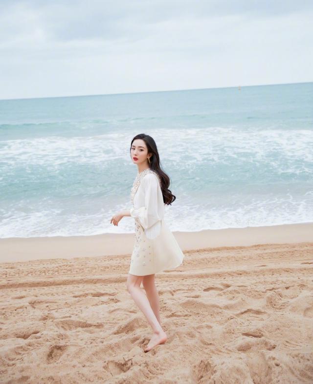 炫的画面杨幂海边写真曝光面朝大海手持鲜花赤脚踏浪画面唯美动人