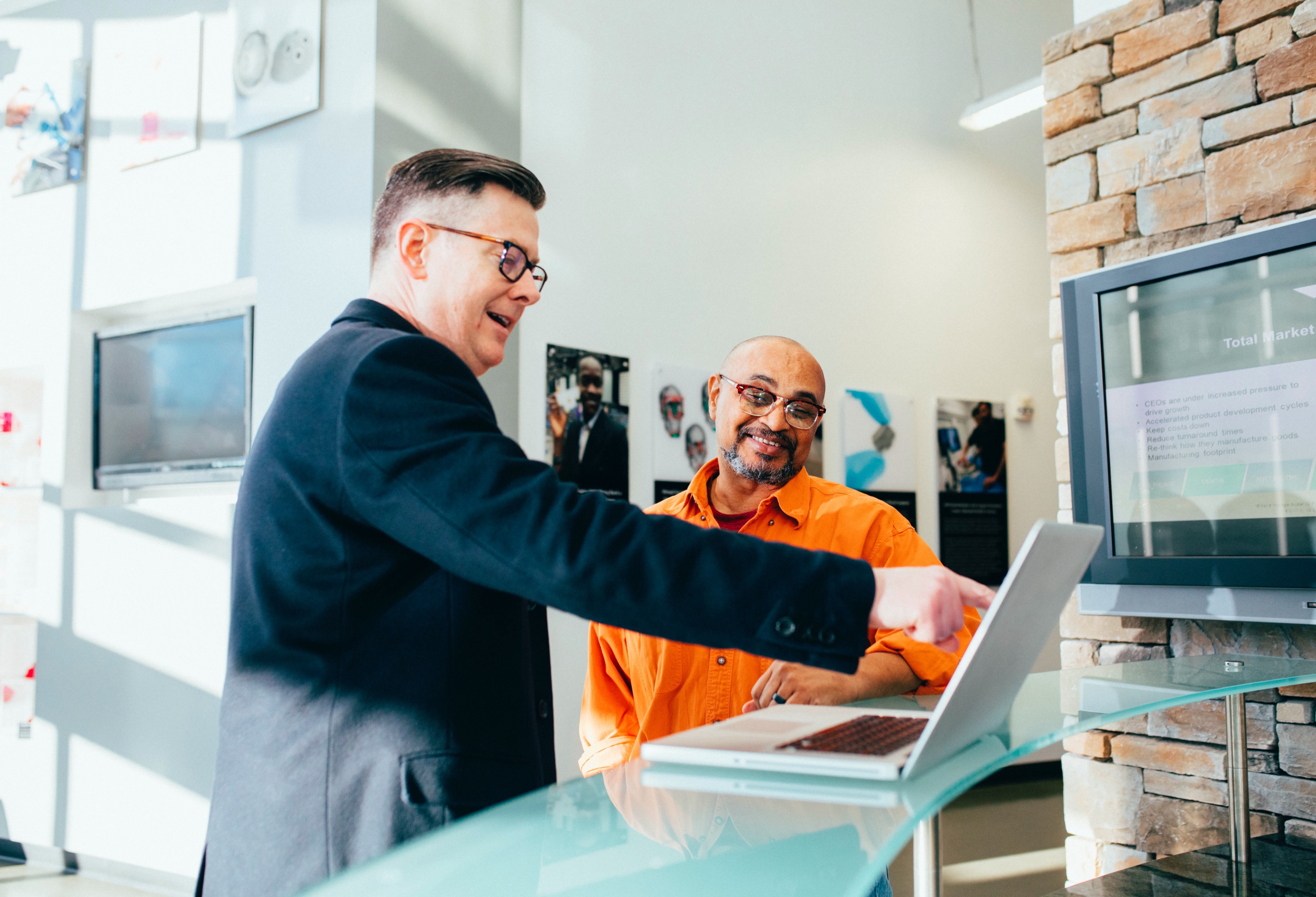 two men pointing at computer screen and smiling