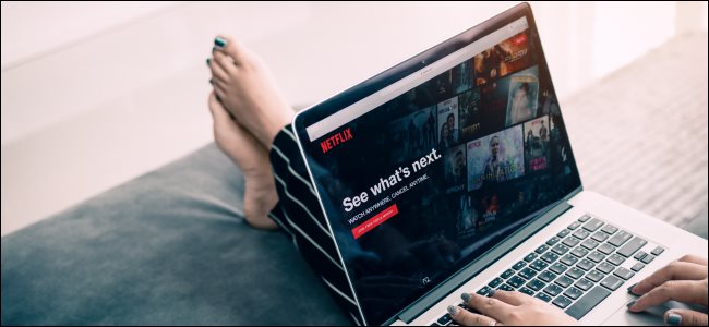 A woman watching Netflix on a laptop.