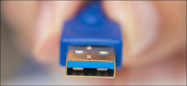 A man holding a USB Type-A connector with blue inside.