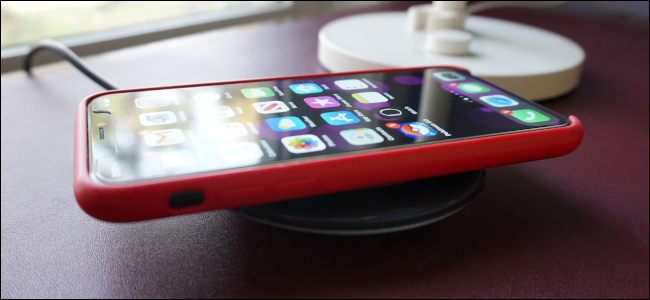 An iPhone sitting on a wireless charger.